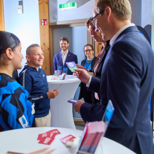 Gyde Opitz (Sparkassen- und Giroverband für Schleswig-Holstein) und Guido Wendt (Staatssekretär) überreichen die ersten Karten an die Schüler*innen der Klasse 6C der Lornsenschule